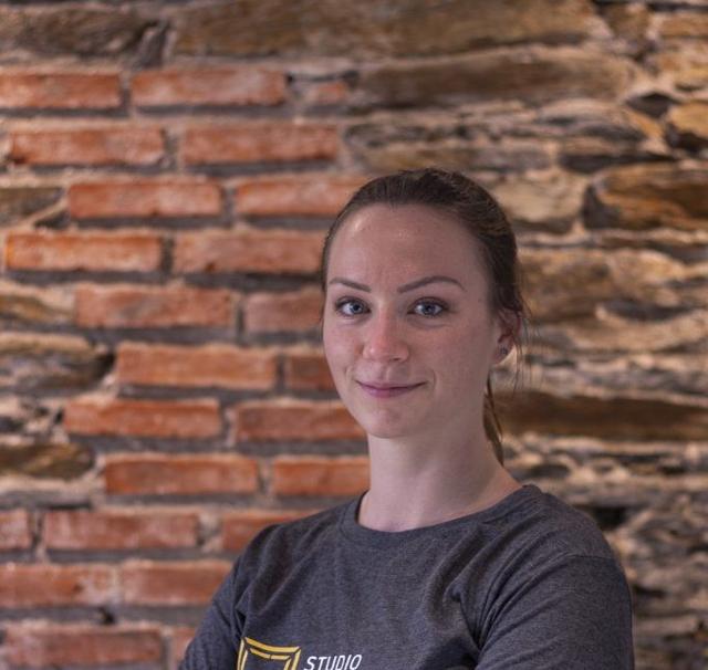 Portrait d'Émilie devant un mur de briques